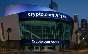 crypto.com arena lit up at dusk with the city skyline in the background.