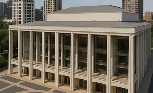 Modern concert hall with a grand plaza and tall buildings in the background.