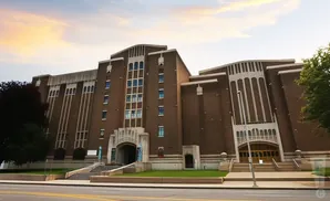 Art deco building with brown brick, white accents, and large windows.