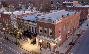 An aerial view of a charming street lined with brick buildings decorated with festive Christmas lights.