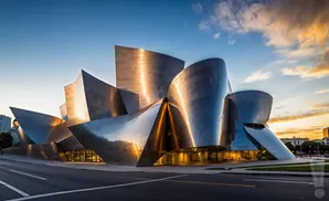 The Walt Disney Concert Hall in Los Angeles at sunset, with its reflective, sculptural design catching the golden light.