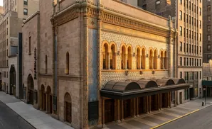 The ornate façade of the Town Hall theater on a street with surrounding buildings.