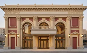 Grand red and cream building with arched windows and a central entrance with double doors.