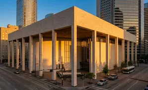 Modern building with colonnade and tall buildings in the background.