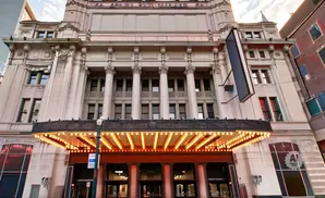 Grand theater entrance with illuminated marquee and ornate classical architecture.