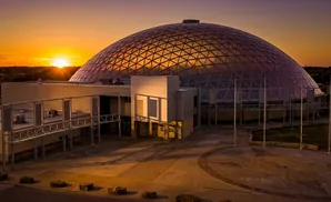 Dome building at sunset, with golden light illuminating the structure and sky.