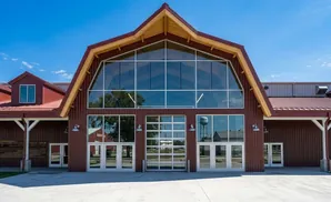 Modern barn with a large glass facade and red metal siding.