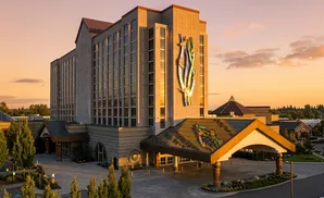 A hotel at sunset with ornate architecture and a large colorful art installation on the facade.