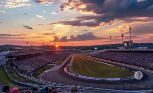 Sunset over a crowded race track stadium with dramatic clouds.