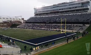An American football stadium with a game in progress and a mostly full crowd.