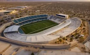 Aerial view of a football stadium surrounded by desert landscape.