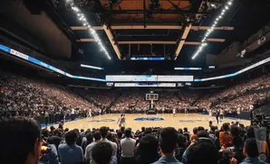 A basketball game in a packed, brightly lit arena with a wide view of the court and stands.