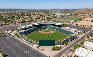 Aerial view of a baseball stadium surrounded by a suburban landscape with distant mountains.
