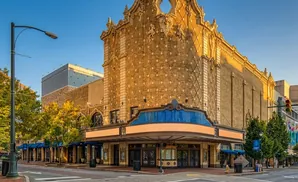 An ornate vintage theater facade with brick and decorative elements, bathed in golden sunlight.