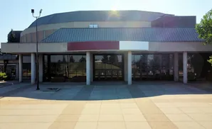 Modern building with a large glass entrance and a curved roof.
