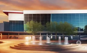 Modern building with blue glass windows and a tiered fountain in front.