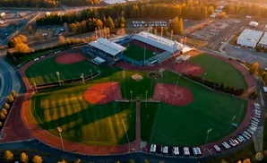 Aerial view of a baseball stadium and fields at sunset.
