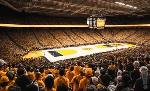 A crowded basketball arena with fans wearing yellow.