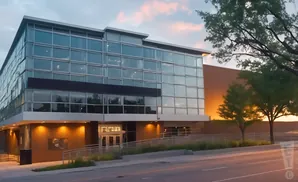 Modern glass and brick building at sunset.