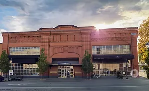 A brick building with large windows and a canopy.