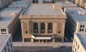 Aerial view of a grand, ornate theater building surrounded by other city buildings.