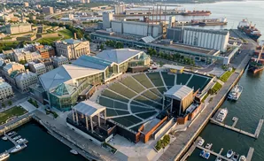 Aerial view of an outdoor amphitheater and port with ships and boats on the water.