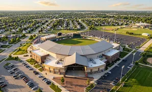 Aerial view of a baseball stadium surrounded by residential areas and parking lots.