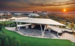 Aerial sunset view of an outdoor amphitheater with tiered seating and a large, modern canopy.