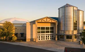 A domed building and two silos with large windows, bathed in warm sunlight.