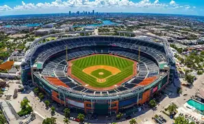 Aerial view of a baseball stadium with a city skyline in the distance.