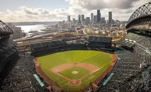 Aerial view of a baseball stadium with a city skyline and water in the background.