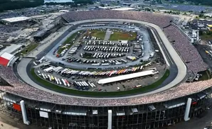 Aerial view of a crowded NASCAR racetrack with stands full of spectators.