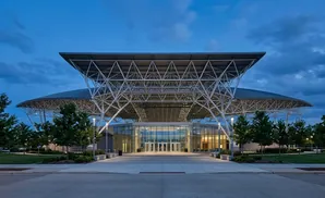 Modern convention center with a large, cantilevered roof supported by a steel exoskeleton.