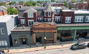 Aerial view of a brick building with businesses on the first floor and apartments above.