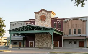 A large building with a green awning and stone accents, under a clear sky.