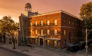 Brick building with a domed cupola, seen at sunset.