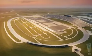 Aerial view of a large oval racetrack with grandstands and parking areas.