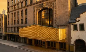 Ornate golden marquee on an historic theater building at sunset.