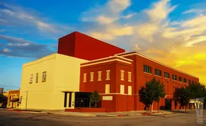 Red and yellow buildings under a dramatic sunset sky with clouds.