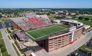 Aerial view of Memorial Stadium in Lincoln, Nebraska, filled with fans for a football game.
