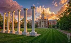 Iconic columns in front of a grand building with a golden dome at sunset.