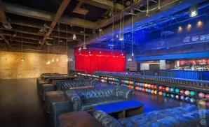 A bowling alley with leather couches and a bar area.