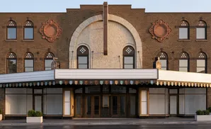 Marquee theater with ornate brickwork, arched windows, and a large marquee sign.