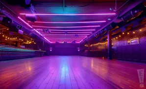 A nightclub with purple and pink neon lights and a wooden floor.