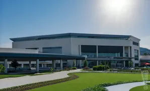 Modern building with a curved driveway and manicured lawn.