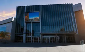 Modern building with a large glass facade and a video screen displaying a city skyline.