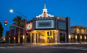 An Improv comedy club at dusk, with lit marquee and traffic lights.