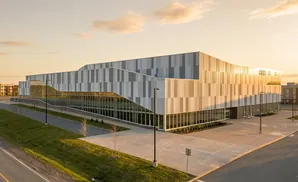 Modern building with a striped facade and large windows at sunset.
