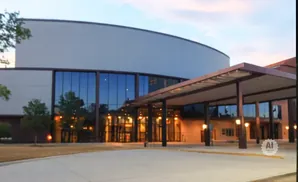 Exterior of a modern building with large glass windows and an entrance canopy.