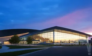 Modern glass building at twilight, with a bright blue and purple sky reflected in the windows.